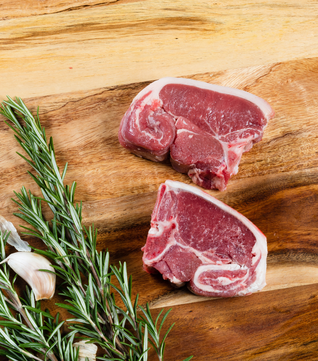 2 fresh versatile cut Rhug Estate Organic Welsh Lamb Loin Chops with garlic and rosemary by side