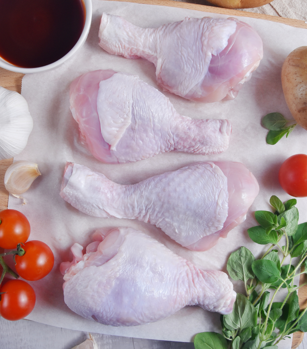 4 fresh Australian Free-range chicken drumsticks with tomato and garlic by side