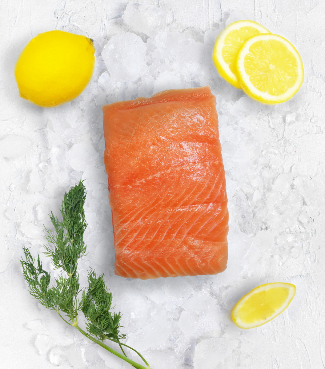 A large portion of fresh Chalk Stream Rainbow Trout with fresh lemon and lemon sliced aside.